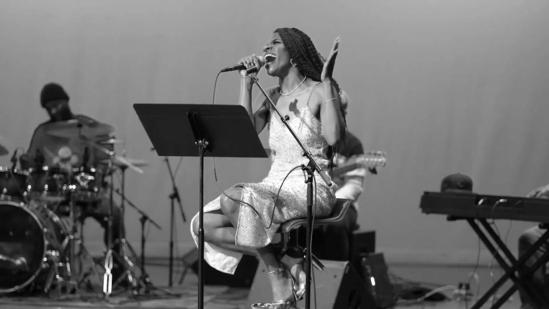 A vocalist singing with her band on stage at the American Jazz Museum